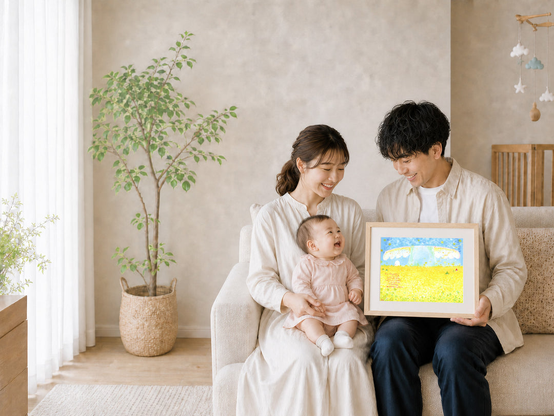 赤ちゃんを抱く家族が、未来への希望を描いた額装された絵をリビングで囲む様子