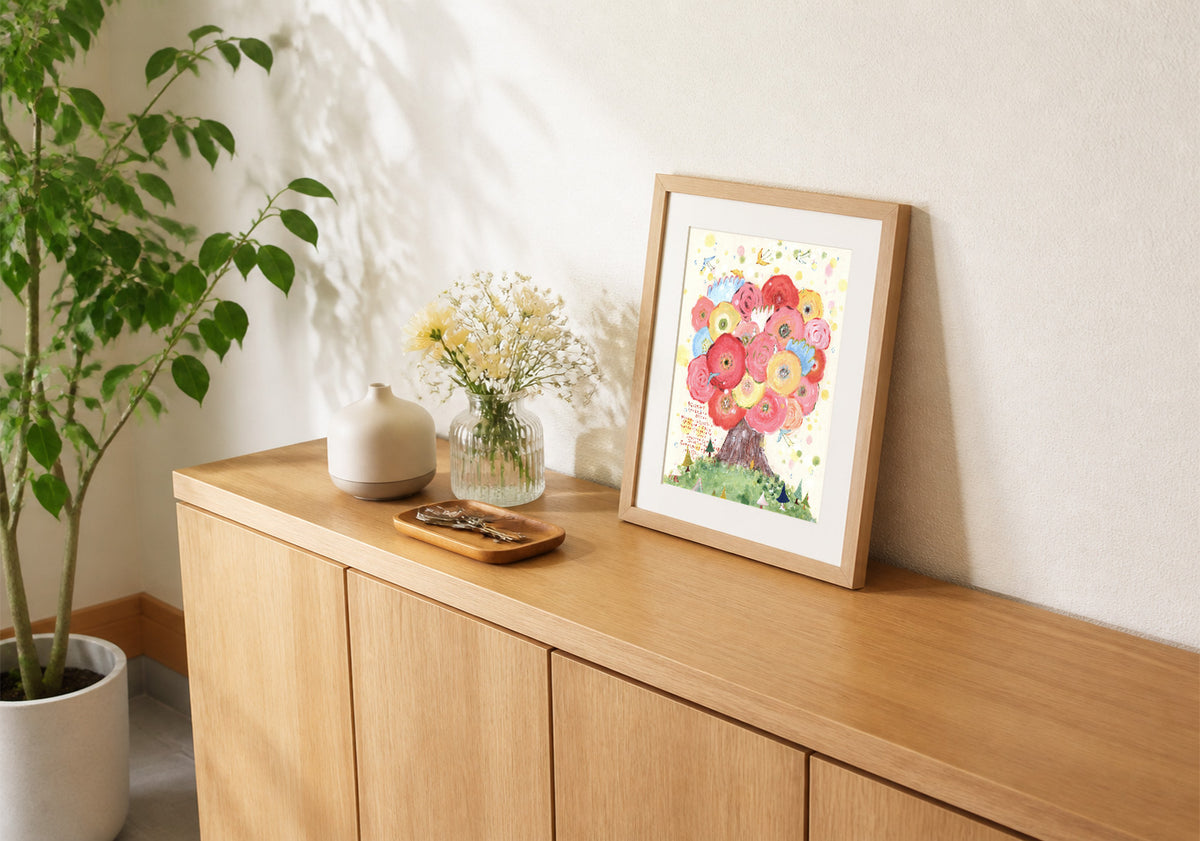 玄関の棚に花や鍵とともに飾られた、咲きつづく日々の額装作品