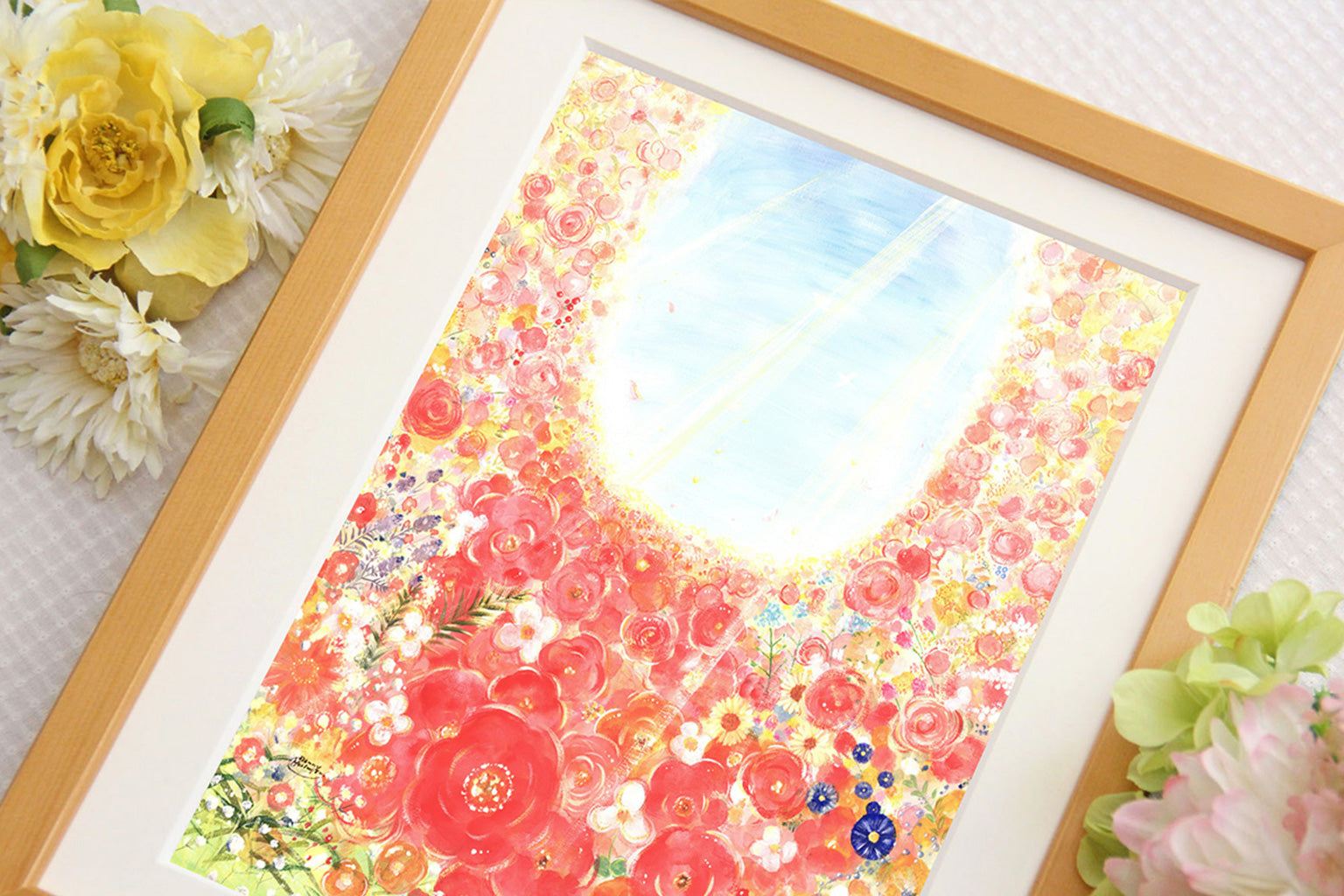 たくさんの花が光へ向かって咲き広がる絵を、花を添えて大きく写した写真