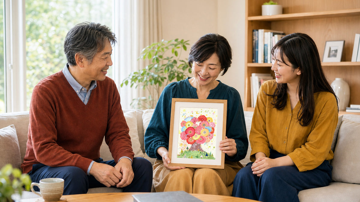 家族から贈られた花の絵を囲み、三人が笑顔を交わす様子