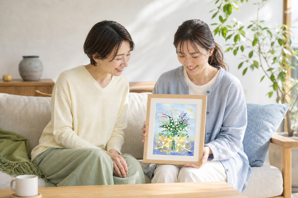 応援の気持ちをこめたすずらんの絵を一緒に眺める二人の女性