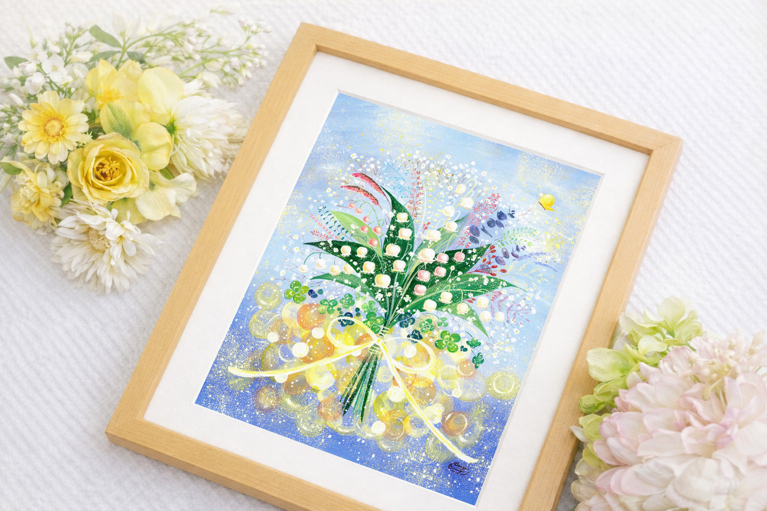すずらんの花束を描いた作品を額に入れて飾った写真