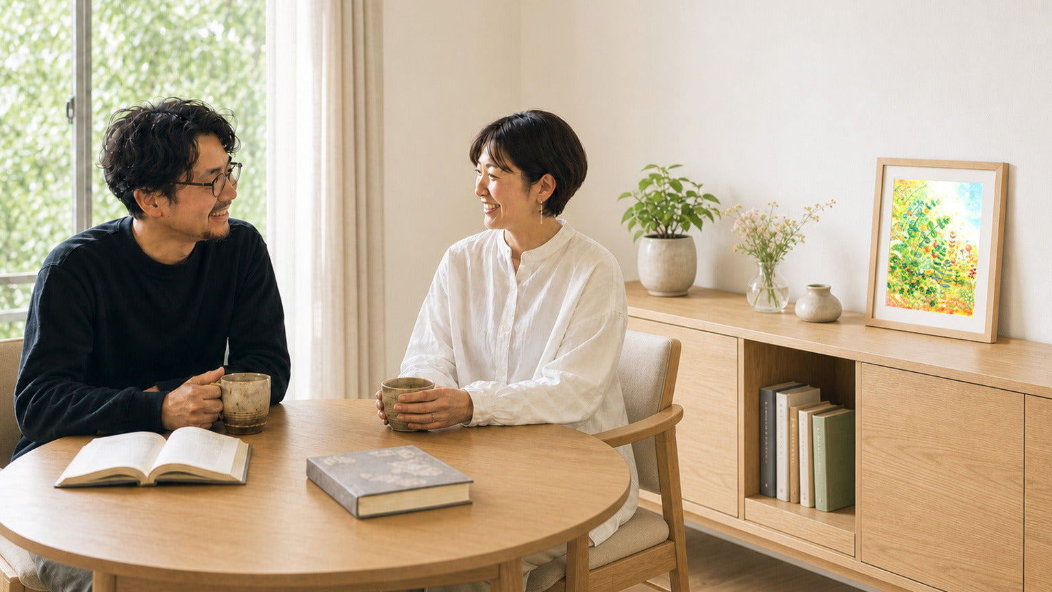 本を楽しむ夫婦のリビングに額装作品が飾られている様子