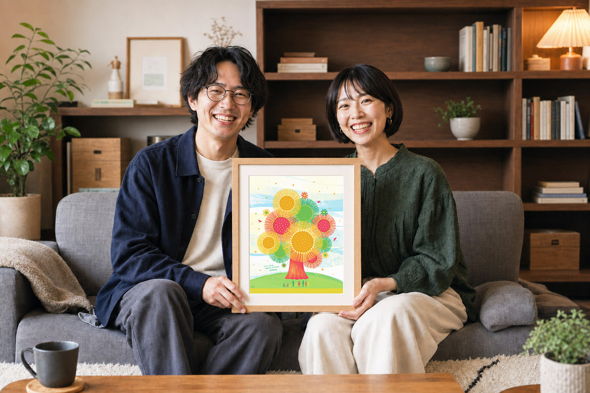 新居で結婚祝いの額装作品を手に笑顔を見せるふたり