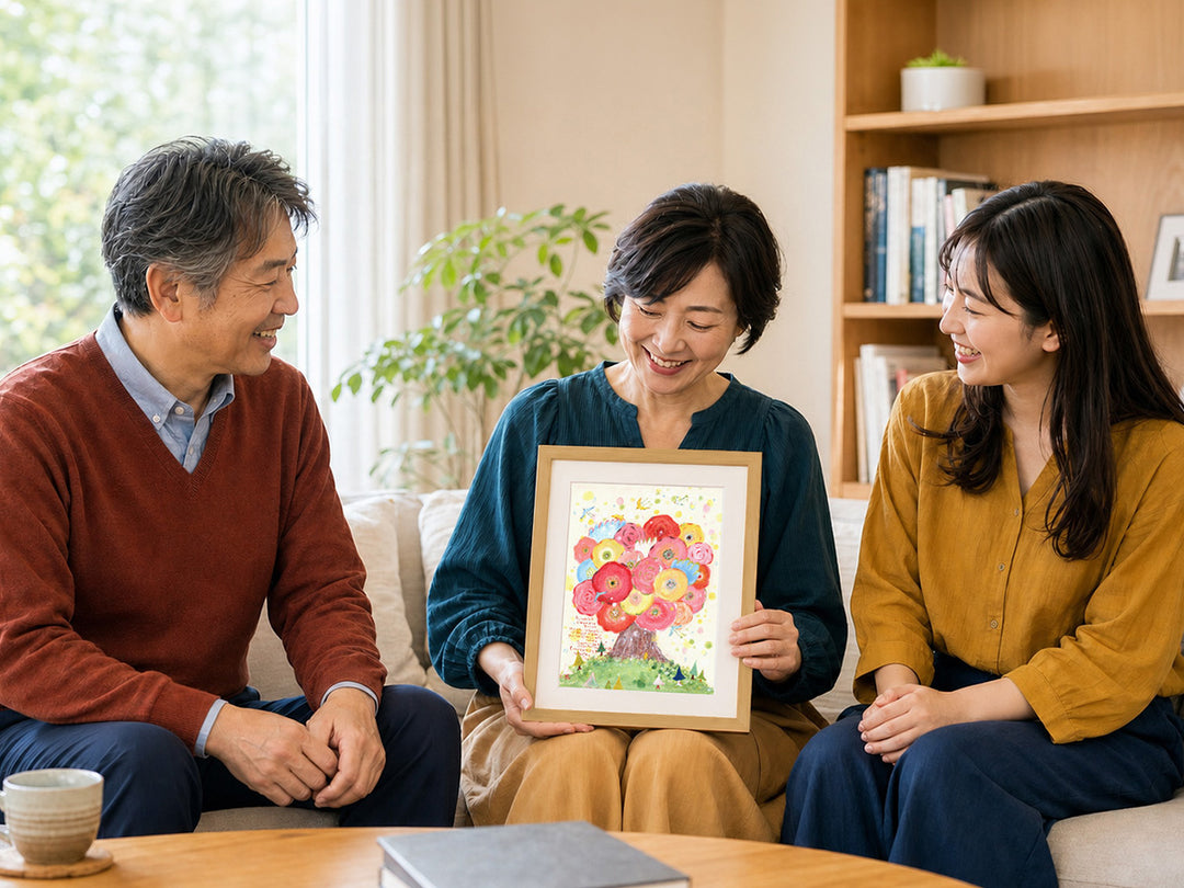 ご両親と娘さんが、贈られた花の木の絵を囲んで笑顔を交わす様子