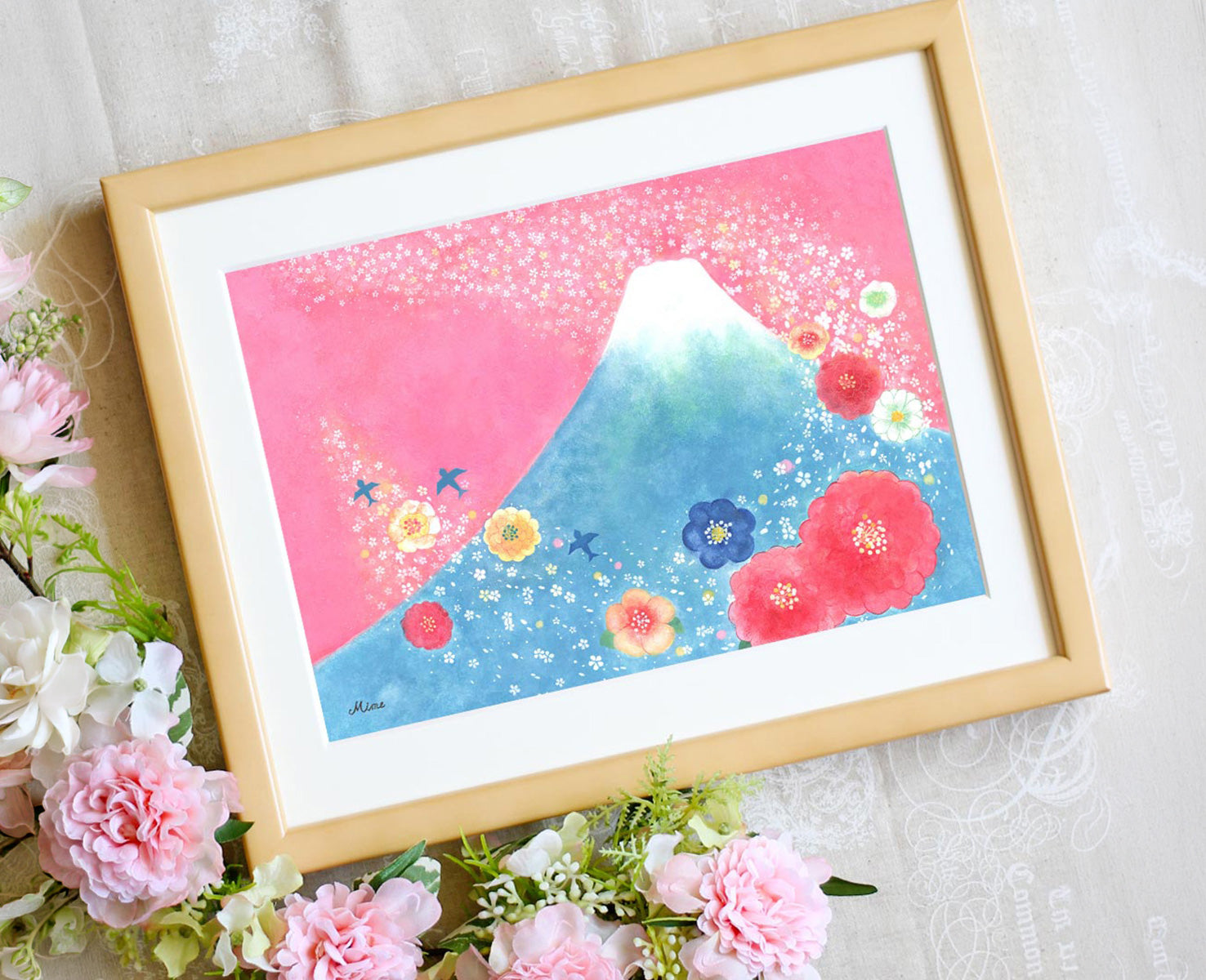 花々に囲まれた富士山の絵を額に入れて飾った写真